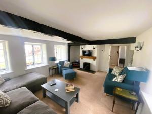 a living room with a couch and a table at April Cottage in Hordle