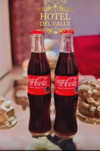 two cocacola bottles sitting on top of a table at Hotel del valle San Miguel 530 in Melipilla