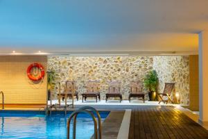Una piscina con sillas al lado de un edificio. en Aparthotel Duva & Spa, en Puerto Pollensa