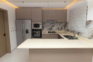a kitchen with a white counter top and a refrigerator at The Riverdale, Kumasi in Kumasi