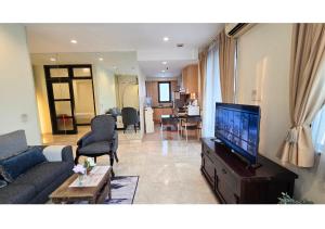 ein Wohnzimmer mit Couch und Flachbildfernseher in der Unterkunft Luxury Apt 85m2, 2 Bedroom at SCBD,Jakarta Convention Ctr,JICC,GBK in Mantaak