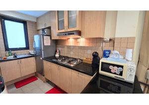 eine kleine Küche mit Mikrowelle und Kühlschrank in der Unterkunft Luxury Apt 85m2, 2 Bedroom at SCBD,Jakarta Convention Ctr,JICC,GBK in Mantaak