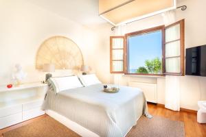 a white bedroom with a bed and a window at Luxury Villa Forte dei Marmi I Gym & View in Strettoia +145 photos