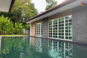 a house with a swimming pool next to a building at 25P Muji Black & White Kajang Villa with 100" TV in Bandar Baru Bangi