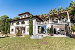 a large house with a fountain in the yard at Luxury Villa Forte dei Marmi I Gym & View in Strettoia