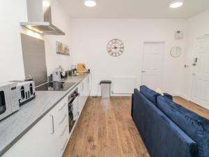 a living room with a blue couch in a kitchen at One in Peterborough
