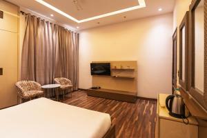 a hotel room with a bed and a tv at Luxury HomeStay Prime Location, South Delhi in New Delhi