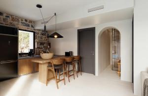 a kitchen with a wooden table and chairs at Volta Seaside Boutique Hotel in Kokkíni Khánion