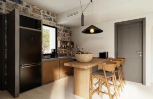 a kitchen with a black refrigerator and wooden cabinets at Volta Seaside Boutique Hotel in Kokkíni Khánion +28 photos