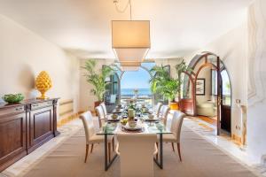 a dining room with a table and chairs and the ocean at Luxury Villa Forte dei Marmi I Gym & View in Strettoia