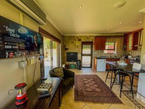 a living room with a couch and a kitchen at Spacious mountain-view haven in Stellenbosch