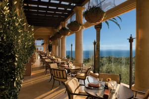 a restaurant with tables and chairs with a view of the ocean at The Resort at Pelican Hill in Crystal Cove