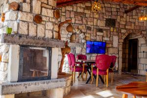 a stone room with a fireplace and a table and chairs at Ekinoks Hotel in İznik