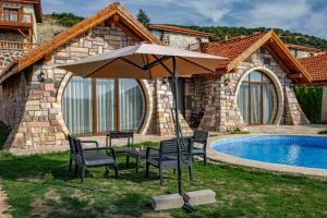 a table and chairs under an umbrella next to a pool at Ekinoks Hotel in İznik