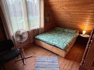 a small bedroom with a bed and a window at Pirts Baudas in Sīveci