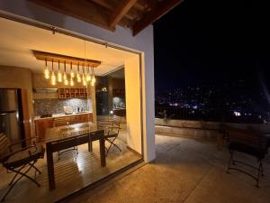 a dining table and chairs on a balcony at night at SereneVbes - Kandy in Kandy