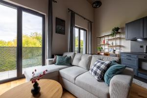 a living room with a couch and a table at Homewell Premium Lofts - free parking in Poznań