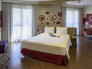 a bedroom with a large bed with a laptop on it at Mercure Sao Paulo Alamedas in Sao Paulo
