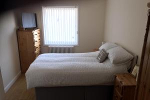 a small bedroom with a bed and a window at Beautiful 3-Bed Apartment in Gourock in Gourock