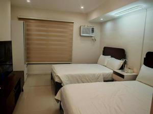 a hotel room with two beds and a window at Cebu CozyStay in Mandaue City +15 photos