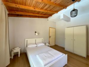 a bedroom with a white bed and a wooden ceiling at With the comfort of home in Kemer