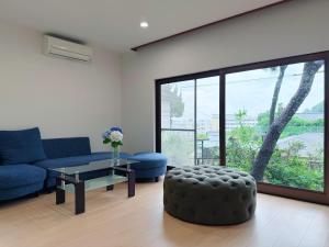 a living room with a blue couch and a table at Okayama Garden House Near Station Free Parking in Okayama