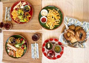 a table topped with plates of food and french fries at With the comfort of home in Kemer