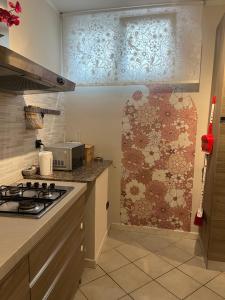 una cocina con fogones y una pared de mosaico en Casa Carlotta, en Nizza Monferrato