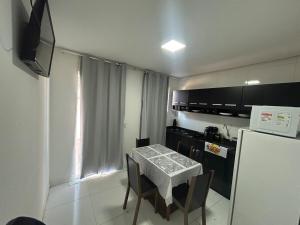 a small kitchen with a table and a refrigerator at Casa siles in Mucugê