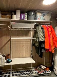 a walk in closet with a rack of clothes at Modern Cabin With Views Of Langsua National Park in Steinsetbygdi +30 photos