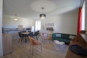 a living room with a couch and a table and chairs at Gîte Les Champs N°2 in Saint-Mathieu