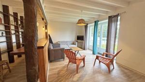 a living room with a couch and a table and chairs at Gîte Les Champs N°3 in Saint-Mathieu