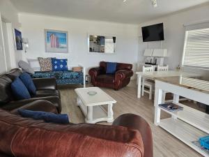 アイゼルフォンテンにあるOn The Beach Apartmentsのリビングルーム(革製家具、テーブル付)