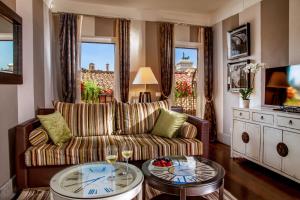 a living room with a couch and a table with wine glasses at The Inn at the Roman Forum Luxury Collection - The Inn At The Roman Forum in Rome