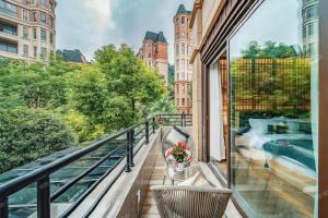 a balcony with a view of a swimming pool at Heinemann Hotel courtyard or terrace king room B106 with a jacuzzi and a local in Baoguosi