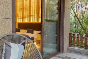 a screened in porch with a chair and a bed at Heinemann Hotel courtyard or terrace king room B106 with a jacuzzi and a local in Baoguosi +5 photos