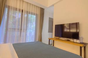 a bedroom with a bed and a flat screen tv at Heinemann Hotel courtyard or terrace king room B208 with a jacuzzi and a local in Baoguosi