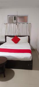 um quarto com uma cama grande e uma almofada vermelha em The Hotel Tirupati Residency em Kota