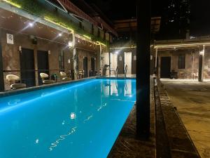 a swimming pool at night with blue lighting at The Century Hostel George Town 乔治市世纪青旅 in George Town