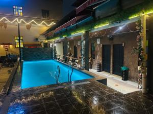 a swimming pool in front of a building at night at The Century Hostel George Town 乔治市世纪青旅 in George Town