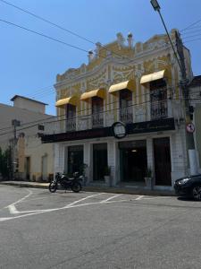 une moto garée dans un parking devant un bâtiment dans l'établissement Pousada Três Arcanjos, à Cachoeira Paulista