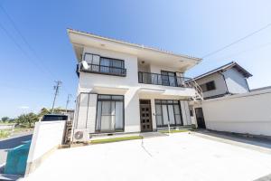 a white house with a driveway in front of it at Miraie Yatomi Large house in Yatomi 
