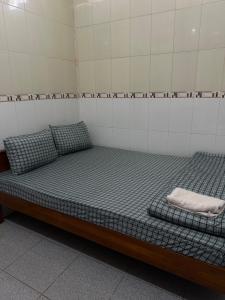 a bed in a room with two pillows on it at Nhà Trọ Thuý Vy in Tri Tôn