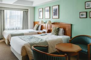 a hotel room with two beds and a chair at Hotel Boston Plaza Kusatsu in Kusatsu +122 photos