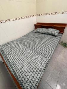 ein Bett in einem Zimmer mit gefliester Wand in der Unterkunft Nhà Trọ Thuý Vy in Tri Tôn