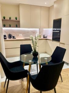 a dining room with a glass table and chairs at Logement aux portes de Monaco in Cap d'Ail