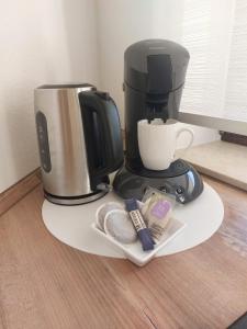 a coffee maker on a white plate with a coffee pot at Ferienwohnung Familie Aestel in Altensteig