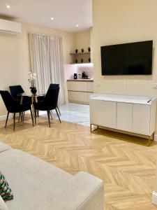 a living room with a television and a table with chairs at Logement aux portes de Monaco in Cap d'Ail