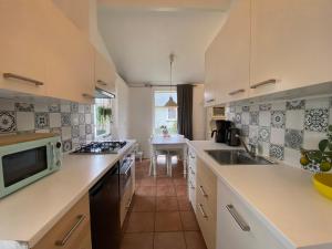 a kitchen with a sink and a microwave at Bungalow 007 in Petten