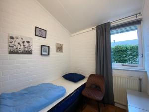 a room with a bed and a window and a chair at Bungalow 007 in Petten +12 photos